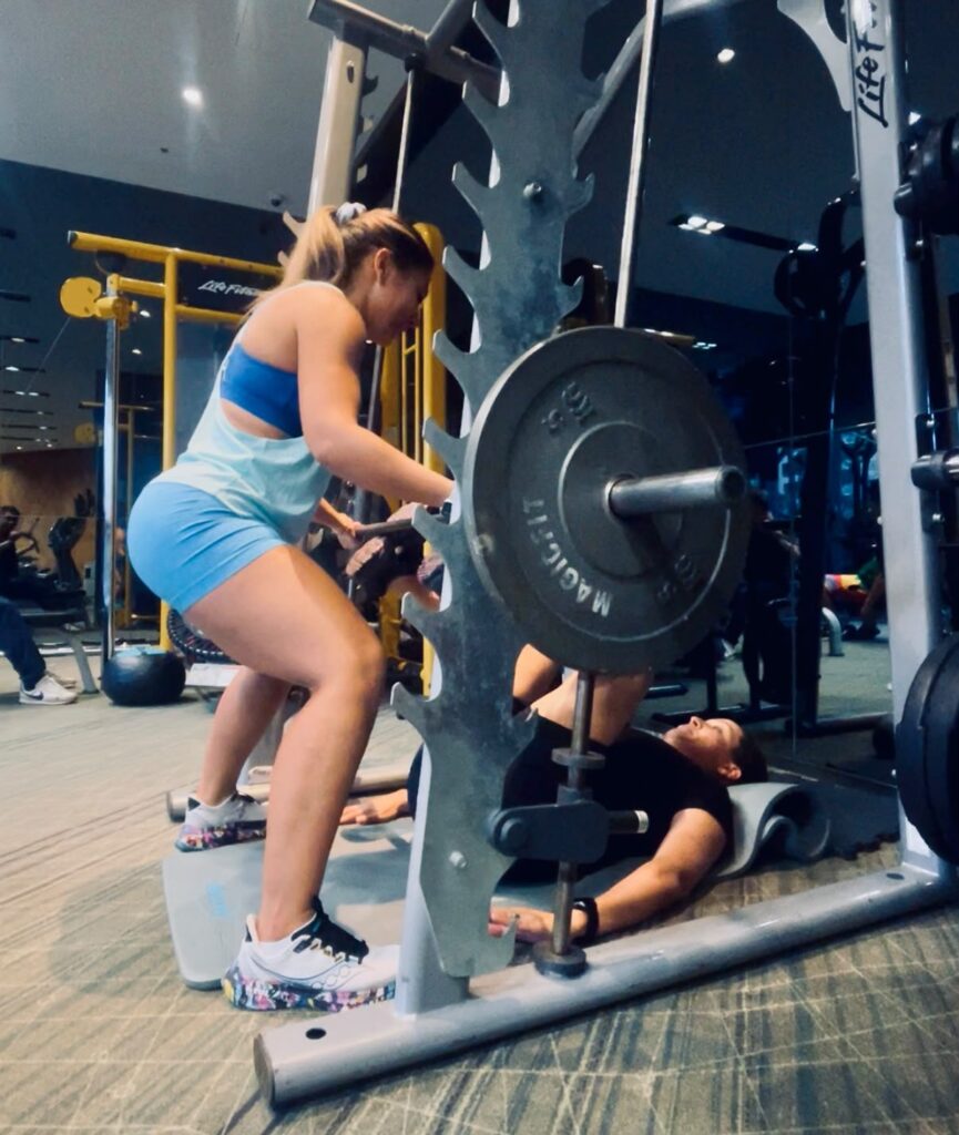 Woman performing strength training with guidance from Dr. Nair Cardoso at a gym in Macau.